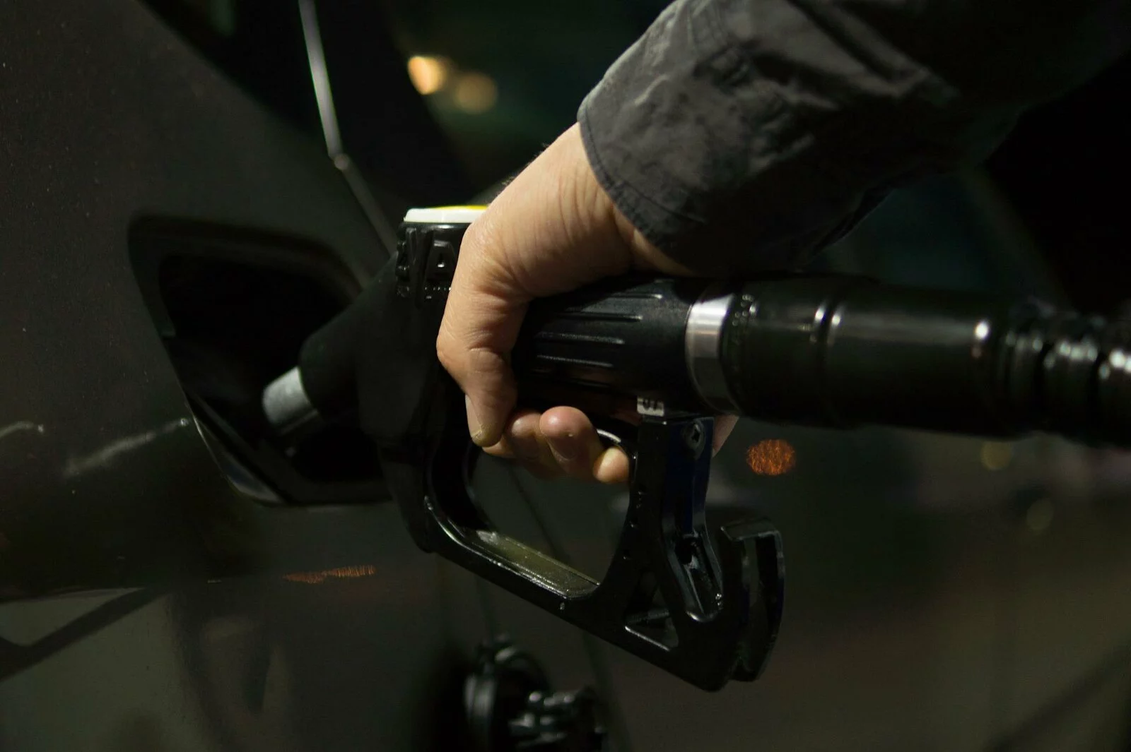 Man holding a nozzle and pouring premium fuel at a Farstad Oil location in Northern USA.